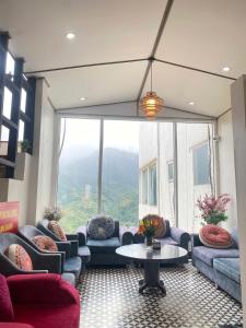 a room with couches and a table and a large window at Terravia Hotel Sapa Moutain View in Sapa