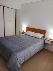 a bedroom with a large bed and two night stands at Complejo Los Arrayanes - Plottier in Plottier