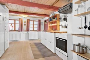 a kitchen with white appliances and wooden ceilings at 20611-Samso-Brundby-Hovedgade-66 in Brundby