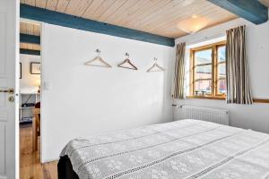a white bedroom with a bed and a window at 20611-Samso-Brundby-Hovedgade-66 in Brundby