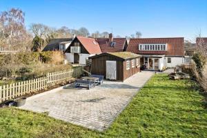 a house with a patio and a fence at 20611-Samso-Brundby-Hovedgade-66 in Brundby