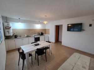a kitchen with a table and chairs in a room at Complejo Los Arrayanes - Plottier in Plottier
