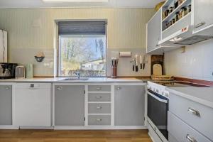 a kitchen with white cabinets and a window at 20103-Samso-Teglvaerksvej-2 in Brundby