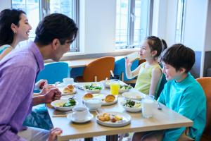 a group of people sitting around a table eating food at Centara Life Namba Hotel Osaka in Osaka
