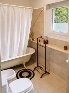 a bathroom with a tub and a toilet and a shower at Casa Verde in La Cumbre +8 photos