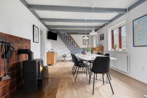a dining room with a table and a wood stove at 20333-Samso-Havvejen-61 in Sælvig