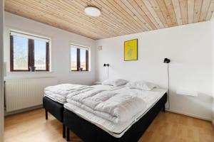 a large bed in a room with a wooden ceiling at 20333-Samso-Havvejen-61 in Sælvig