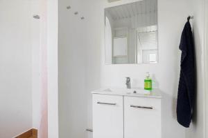 a white bathroom with a sink and a mirror at 20333-Samso-Havvejen-61 in Sælvig +20 photos