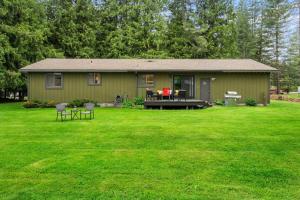 a green house with a table and chairs in a yard at Cedar Trees Retreat in Sandpoint