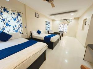 a hotel room with two beds and a chair at Hotel Sri Ram in Similigurha