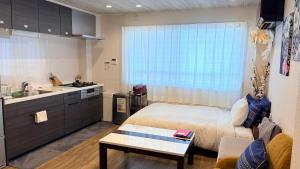 a small bedroom with a bed and a kitchen at Nagoya Minpaku, KANAYAMA BASE in Mutsunochō