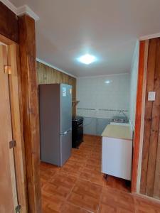 a small kitchen with a refrigerator and a sink at Cabaña Los Cactus en Mamalluca in El Durazno