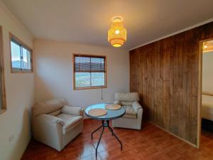 a living room with a table and two chairs at Cabaña Los Cactus en Mamalluca in El Durazno +1 photo