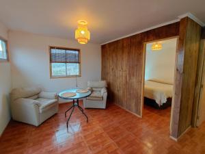 a living room with a table and a couch and a bed at Cabaña Los Cactus en Mamalluca in El Durazno