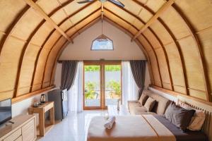 a bedroom with an arched ceiling with a bed and a couch at Arc Villas Bali in Ketewel