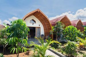 a house with a curved roof in a garden at Arc Villas Bali in Ketewel
