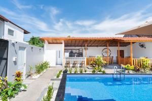 a villa with a swimming pool and a house at Arc Villas Bali in Ketewel