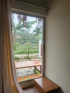 a window with a view of a picnic table at Ananda Uthaan in Sreemangal +5 photos