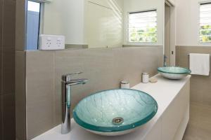 a bathroom with a blue sink and a mirror at Reflections Turquoise Villa 4 in Picnic Bay +10 photos