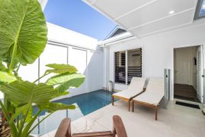 a patio with a table and chairs and a pool at Reflections Turquoise Villa 4 in Picnic Bay