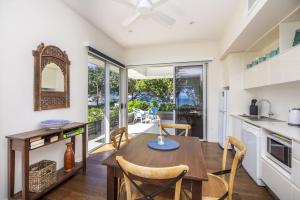 a kitchen and dining room with a table and chairs at Reflections Turquoise Villa 4 in Picnic Bay