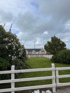 a white fence in front of a house at Erris house in Belmullet