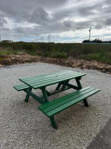 a picnic table and two benches on a gravel field at Erris house in Belmullet