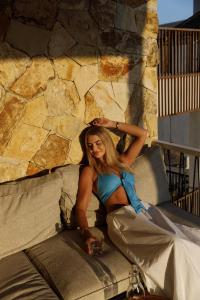 a woman in a blue dress sitting on a couch at Pagi Villas by Betterplace in Canggu