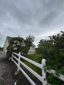 a white fence in front of a white house at Erris house in Belmullet