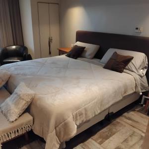 a large white bed in a room with a chair at VICTORIA BED and BREAKFAST 1 A 3KM AEROPUERTO EZEIZA in Ezeiza +18 photos
