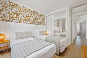 a bedroom with two beds and a painting on the wall at Sunlit Apartment with Balcony & Atlantic Views in Ponta do Sol