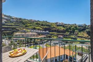 a plate of fruit on a table on a balcony at Sunlit Apartment with Balcony & Atlantic Views in Ponta do Sol