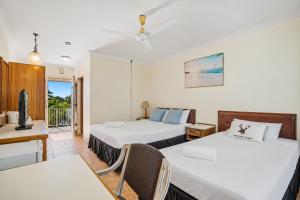 a hotel room with two beds and a balcony at The Reef Motel in Cairns