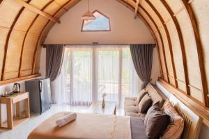 a living room with a large window and a couch at Arc Villas Bali in Ketewel +27 photos