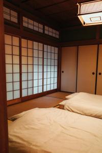 two beds in a room with windows at Kumano Base in Tanabe