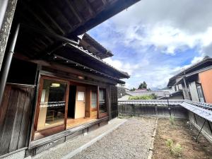 a wooden house with a window on the side of it at Kumano Base in Tanabe