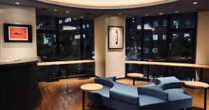 a lobby with blue chairs and tables in a building at Nesthotel alt Kuramae Station in Tokyo