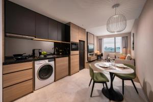 a kitchen and living room with a table and a washer at Fraser Residence Putrajaya in Putrajaya