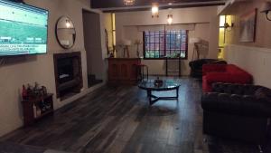 a living room with a couch and a table and a tv at VICTORIA BED and BREAKFAST 1 A 3KM AEROPUERTO EZEIZA in Ezeiza