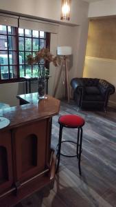 a living room with a red stool and a couch at VICTORIA BED and BREAKFAST 1 A 3KM AEROPUERTO EZEIZA in Ezeiza