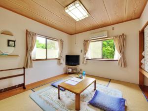 - un salon avec une table et 2 fenêtres dans l'établissement Chateau Le Fleur, à Itō