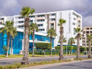 a row of palm trees in front of a building at Mercure Nador Rif in Nador