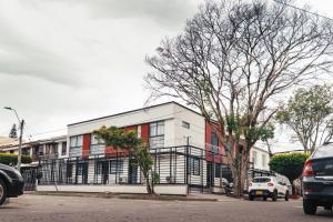 a building on a street with cars parked in front of it at Colseguros in Cali