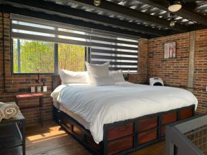 a bedroom with a large bed in a brick wall at Macpalo in Amatlán