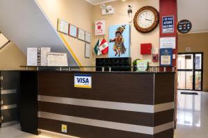 a lobby with a visa counter with a clock on the wall at Hotel Zackenbarsch in Huánuco