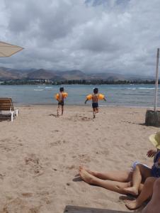 a group of three people playing a game on the beach at Хостел 9 коттедж in Cholpon-Ata
