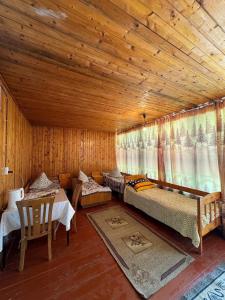 a bedroom with two beds and a table in a room at Хостел 9 коттедж in Cholpon-Ata