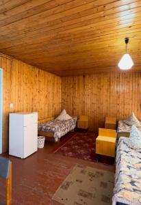 a room with two beds in a room with wooden walls at Хостел 9 коттедж in Cholpon-Ata