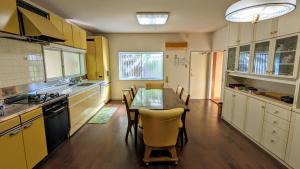 a kitchen with a table and a dining room at ゲストハウスヒスイ in Kuchi-sada +9 photos