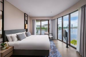 a bedroom with a large bed and large windows at Fraser Residence Putrajaya in Putrajaya +33 photos
